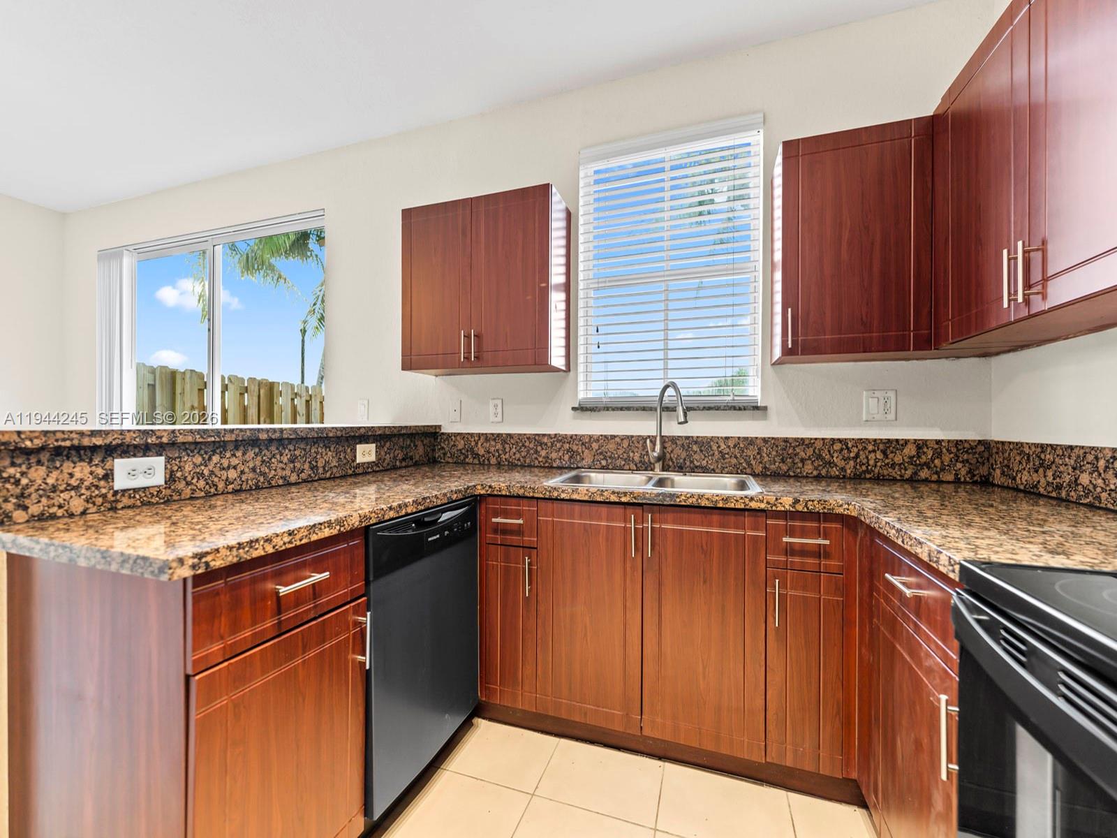 2441 Southeast 14 Street Homestead, FL 33035 - Photo 4 of 32 a kitchen with stainless steel appliances granite countertop a sink stove and cabinets