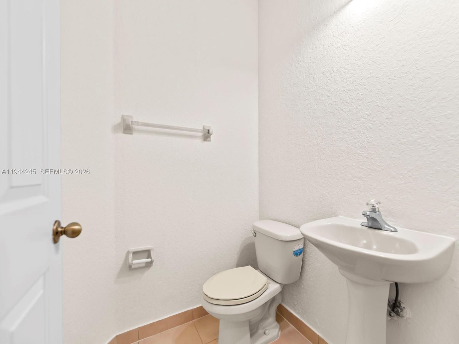 2441 Southeast 14 Street Homestead, FL 33035 - Photo 9 of 32 a bathroom with a sink a toilet and a mirror