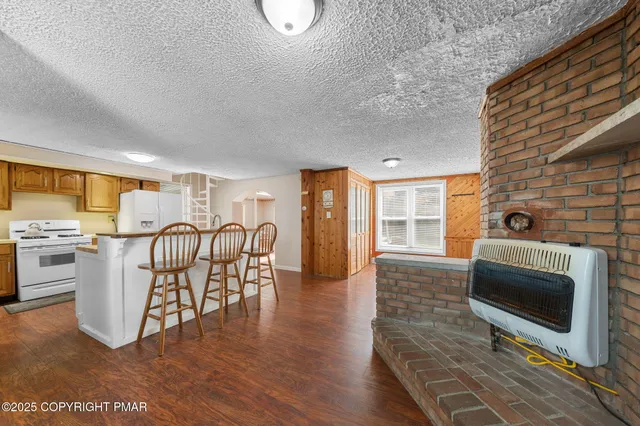 a living room with furniture a fireplace and wooden floor