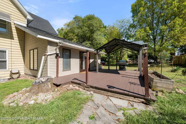 a view of a small house with yard and sitting area