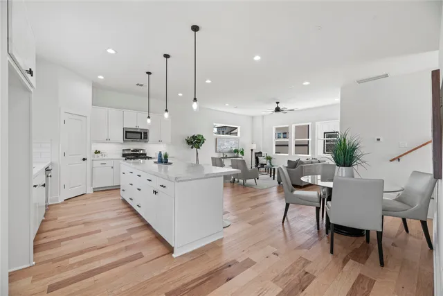 a large white kitchen with lots of furniture and appliances