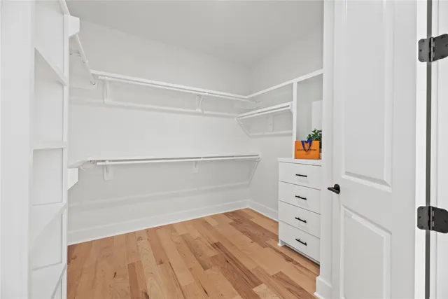 a view of walk in closet with empty racks