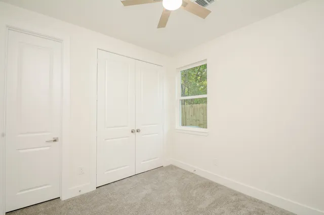 an empty room with windows and closet