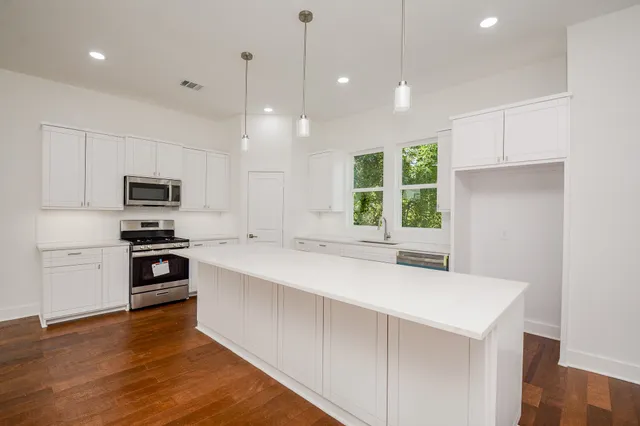 a kitchen with a stove a sink and a microwave