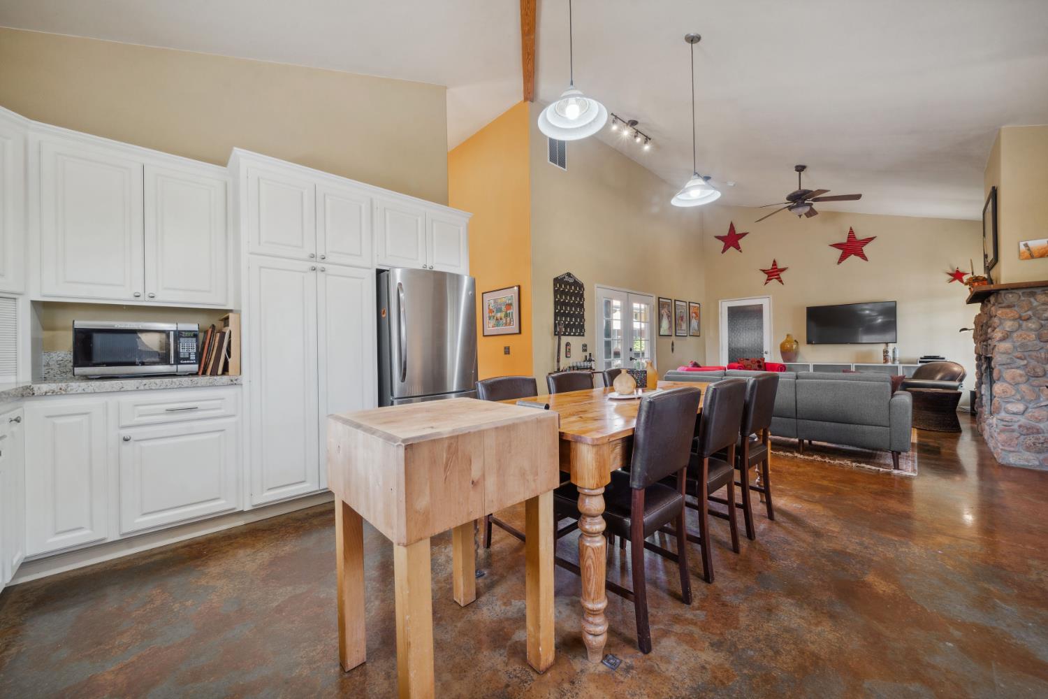 11321 New York Ranch Road Jackson, CA 95642 - Photo 12 of 73 a view of a dining room and livingroom with furniture wooden floor a rug a flat screen tv a rug and a chandelier