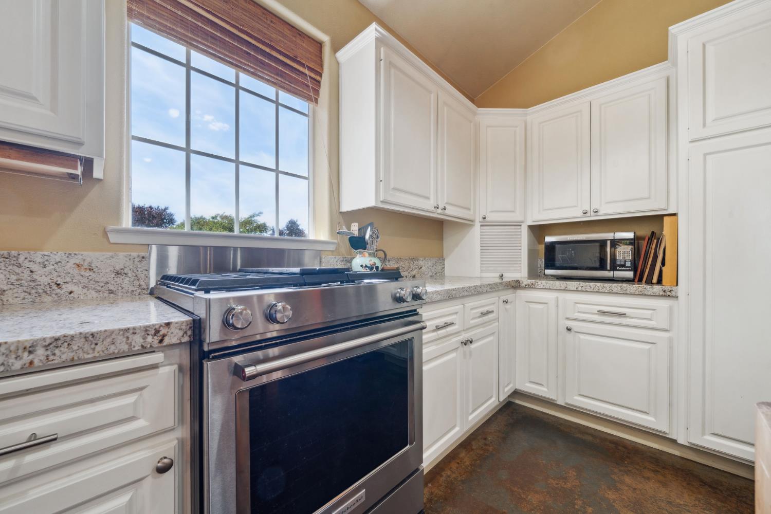11321 New York Ranch Road Jackson, CA 95642 - Photo 13 of 73 a kitchen with granite countertop white cabinets stainless steel appliances and a window