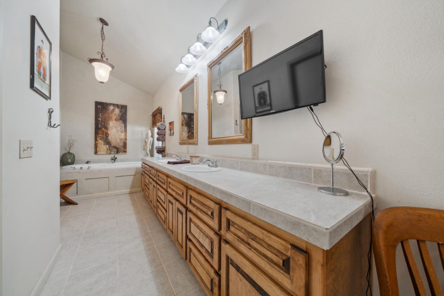 11321 New York Ranch Road Jackson, CA 95642 - Photo 27 of 73 a bathroom with a sink a mirror and a bathtub
