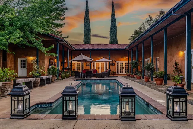 a dining room with furniture and potted plants