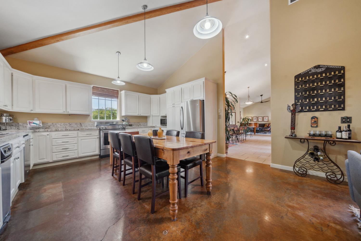 11321 New York Ranch Road Jackson, CA 95642 - Photo 10 of 73 a kitchen with stainless steel appliances a table chairs refrigerator and cabinets