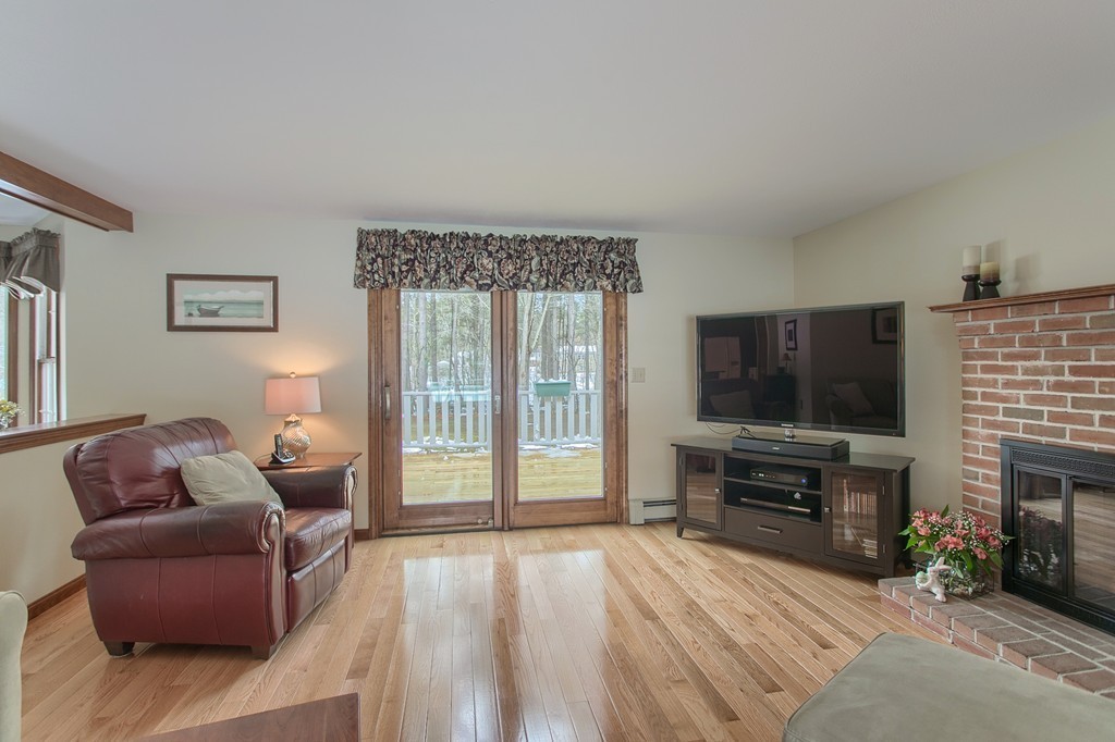 27 Ledge Road Chelmsford, MA 01863 - Photo 7 of 30 a living room with furniture a flat screen tv and a fireplace