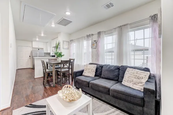 a living room with furniture and wooden floor