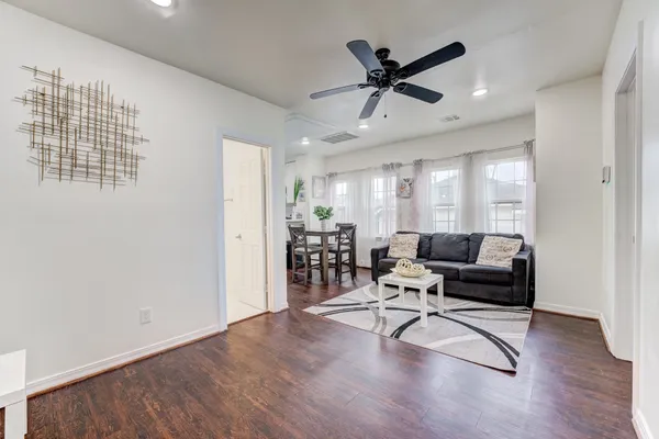 a living room with furniture and a ceiling fan