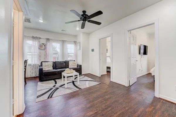a living room with furniture and a wooden floor