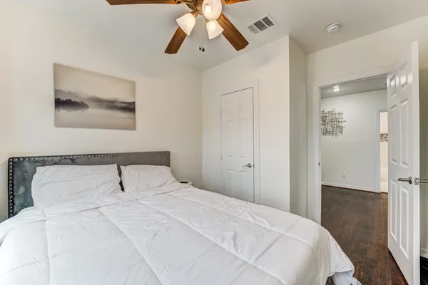 a bedroom with a bed and a painting on the wall