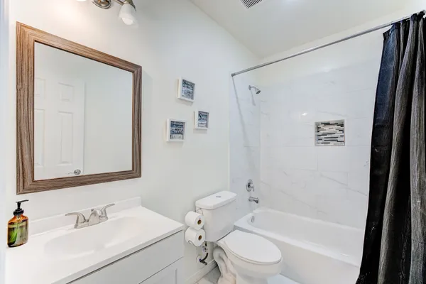 a bathroom with a bathtub shower sink and a toilet