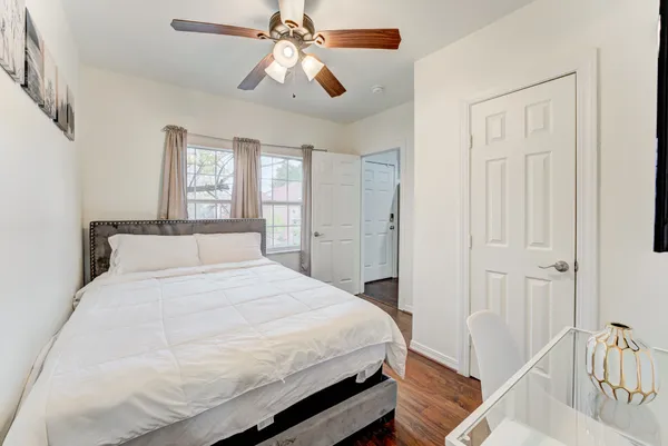 a bedroom with a large bed and a chandelier