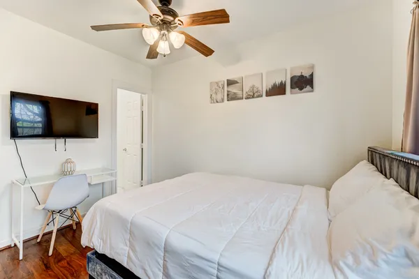 a bedroom with a bed tv and a chandelier