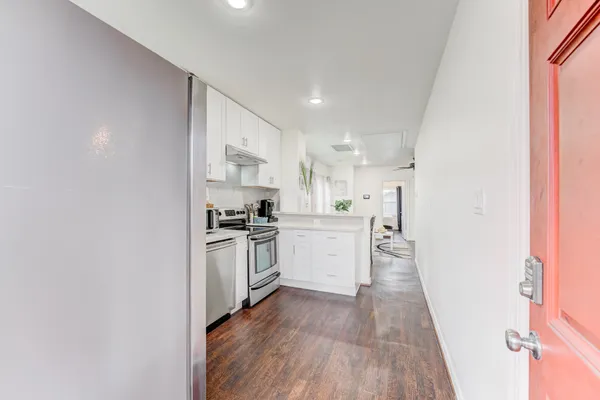 a kitchen with a white stove top oven and white refrigerator
