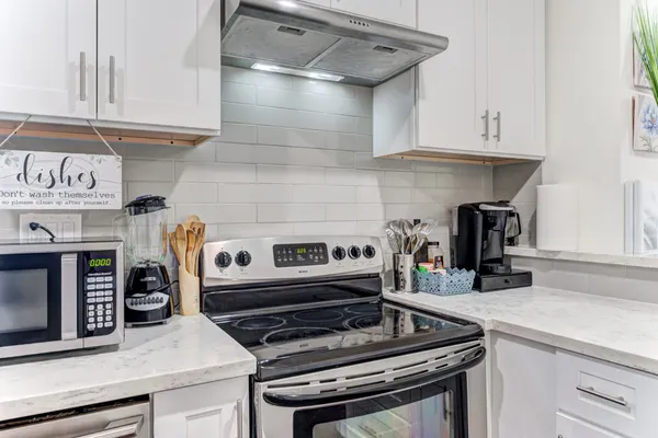 a kitchen with stainless steel appliances granite countertop a stove and a cabinets