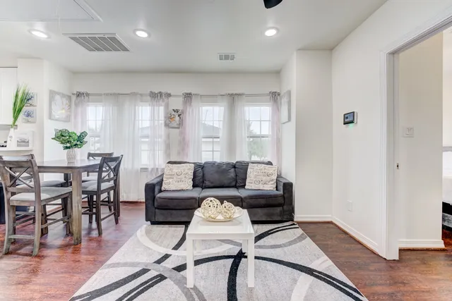 a living room with furniture and wooden floor