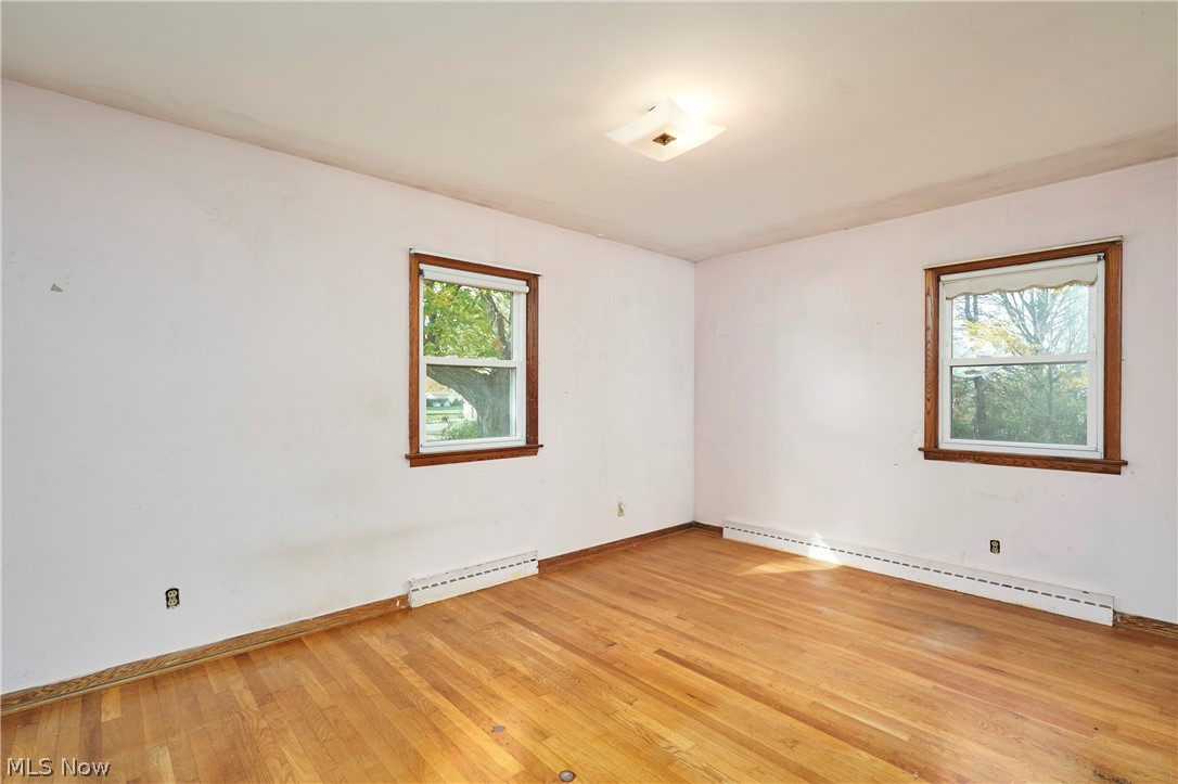 2941 Sweitzer Road Uniontown, OH 44685 - Photo 10 of 16 Empty room with baseboard heating and light wood-style flooring