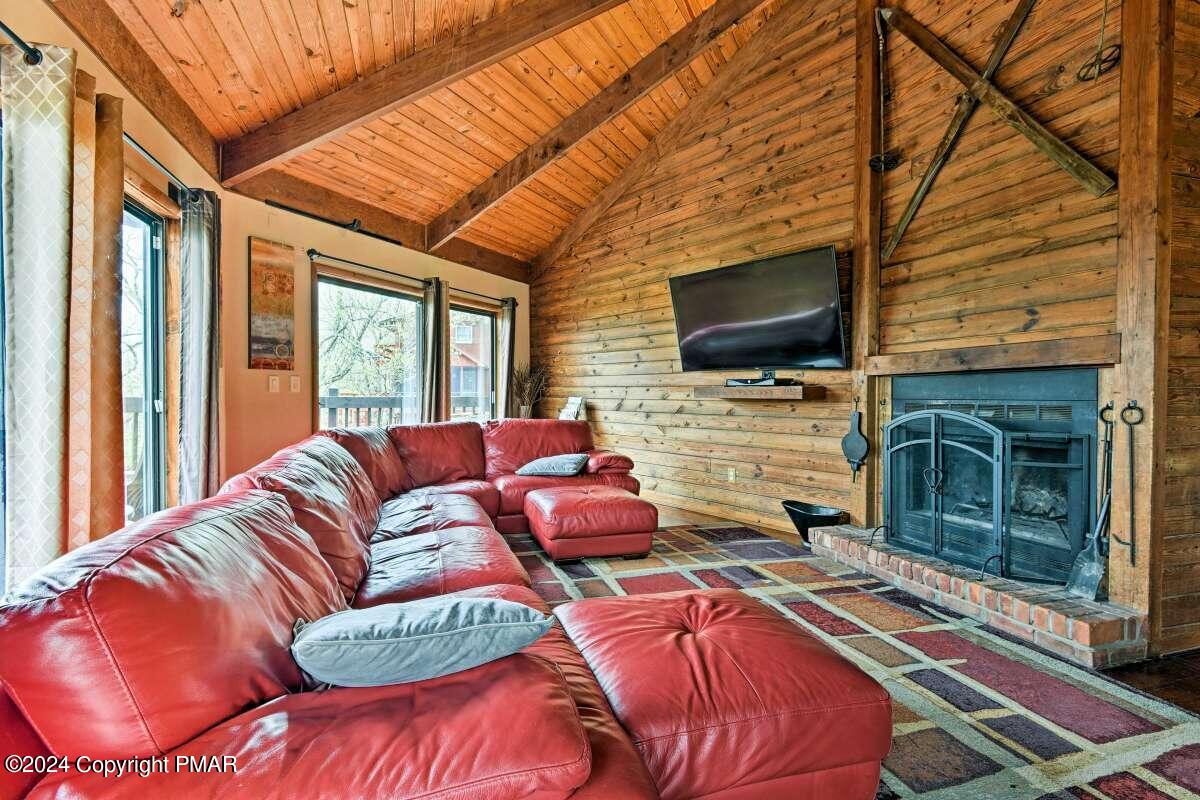 122 Elgin Way Bushkill, PA 18324 - Photo 4 of 32 a living room with furniture a fireplace and a flat screen tv