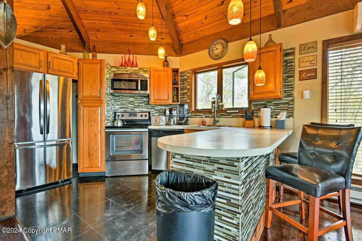 122 Elgin Way Bushkill, PA 18324 - Photo 6 of 32 a kitchen with a table chairs refrigerator and cabinets