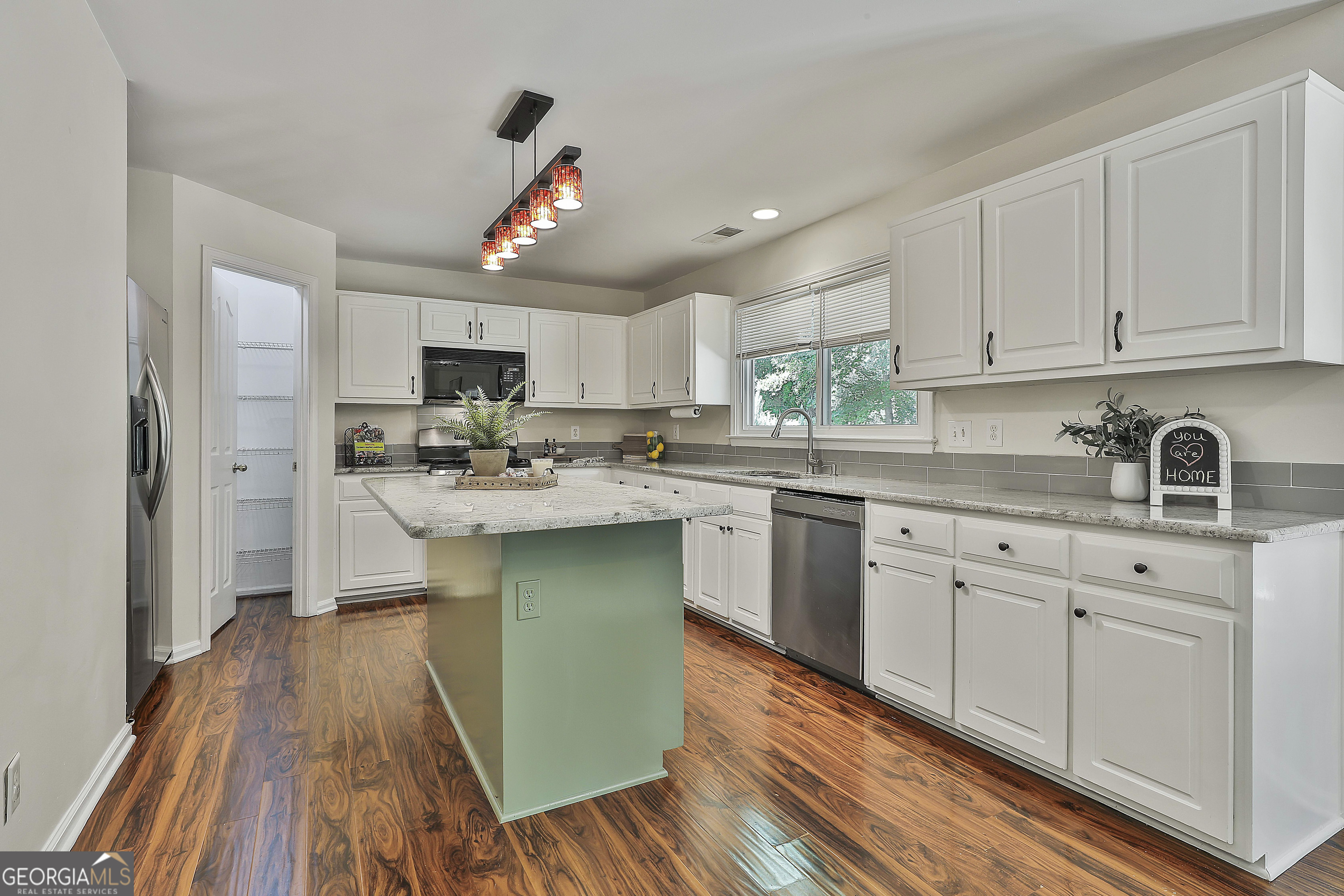244 Terrane Ridge Peachtree City, GA 30269 - Photo 15 of 44 a kitchen with stainless steel appliances granite countertop a sink dishwasher a refrigerator with white cabinets and wooden floor