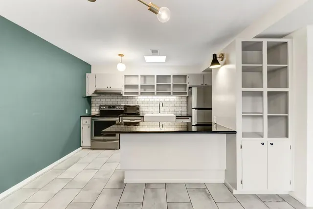 a kitchen with stainless steel appliances a stove and more cabinets