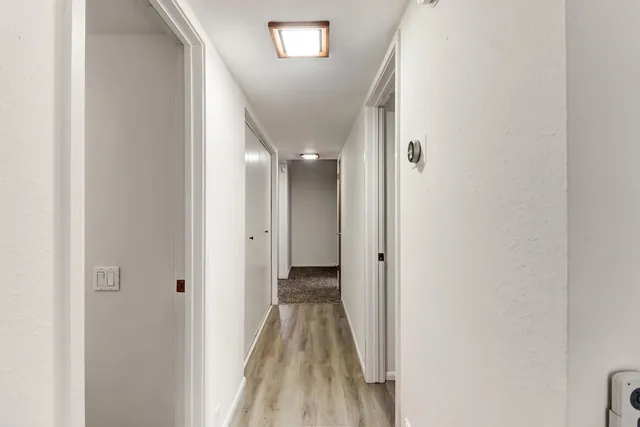 a view of a hallway with wooden floor
