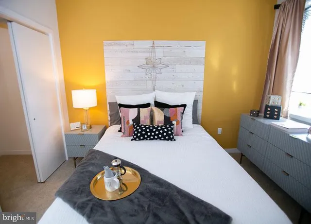 a bed sitting in a bedroom next to a window