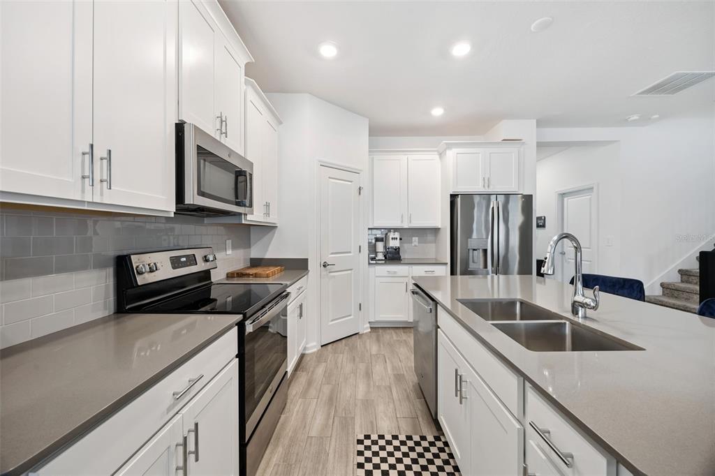 2747 Slash Way St. Cloud, FL 34771 - Photo 11 of 62 a kitchen with stainless steel appliances a sink a stove a microwave a sink a refrigerator and cabinets