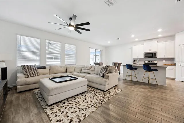 a living room with furniture and a ceiling fan