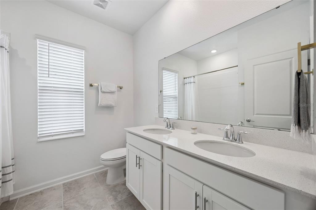 2747 Slash Way St. Cloud, FL 34771 - Photo 34 of 62 a bathroom with a granite countertop sink toilet and mirror