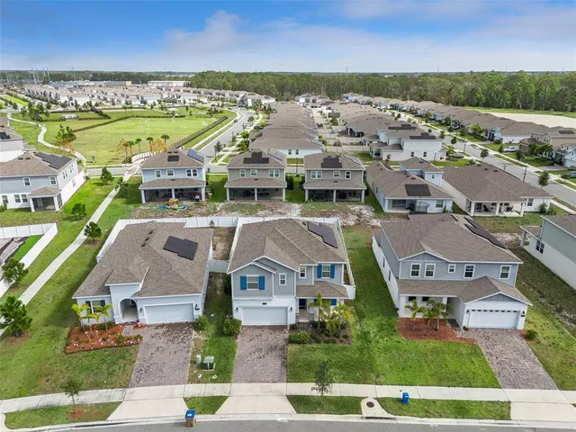 an aerial view of residential houses with outdoor space and lake view