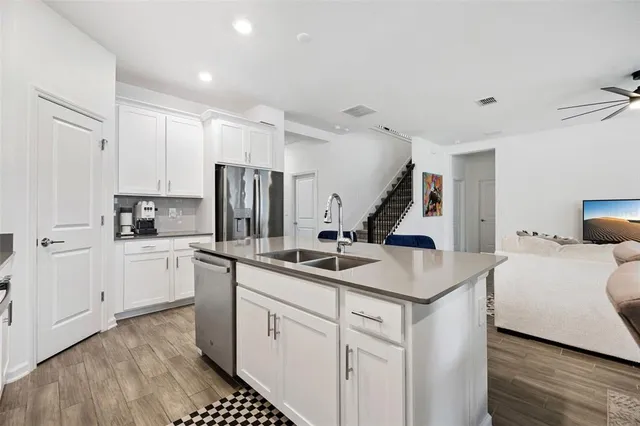 a kitchen with stainless steel appliances a sink a stove a microwave a sink a refrigerator and cabinets