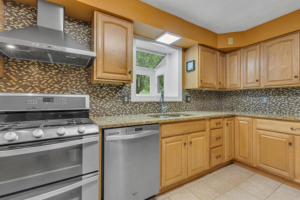 171 Dehaven Road Beaver Falls, PA 15010 - Photo 14 of 35 a kitchen with stainless steel appliances granite countertop a sink stove and cabinets