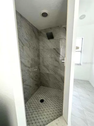 a bathroom with a granite countertop sink a mirror and a bathtub