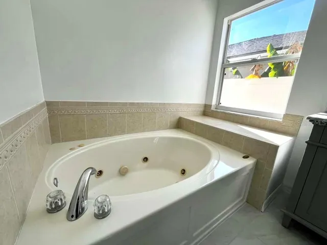 a white toilet sitting in a bathroom next to a window