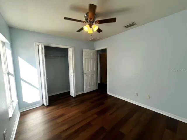 a bathroom with a granite countertop toilet a sink and a mirror