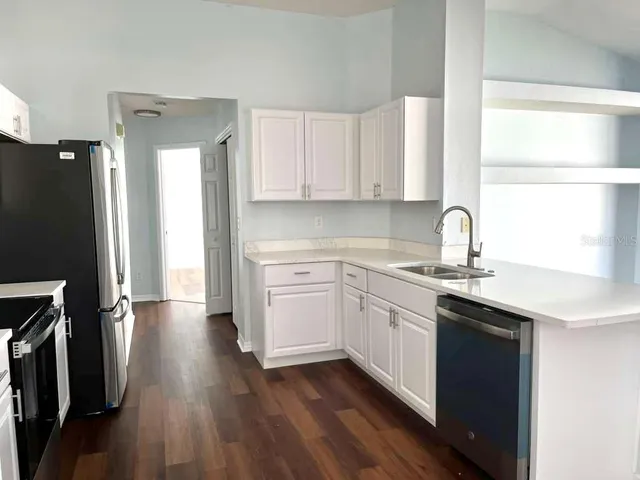 a kitchen with a sink cabinets stainless steel appliances and a window