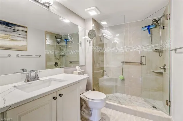 a bathroom with a sink toilet double vanity and shower