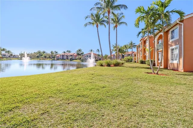 a view of a lake with a big yard and palm trees