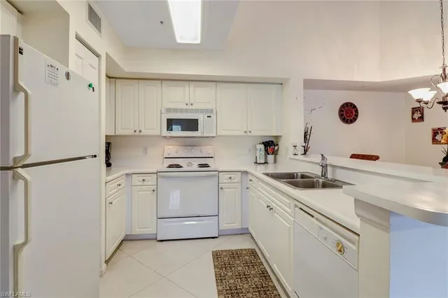 a kitchen with white cabinets and white appliances