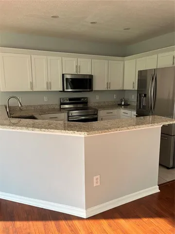 a kitchen with stainless steel appliances a stove a sink a microwave and cabinets