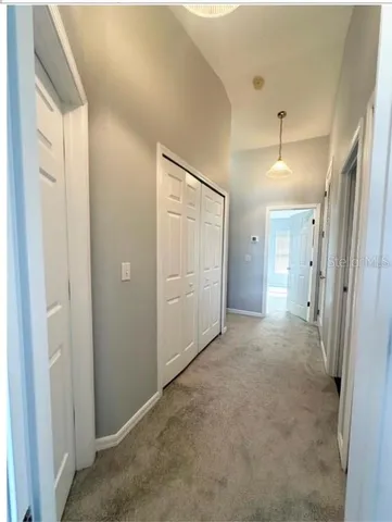 a view of a hallway with wooden shelves