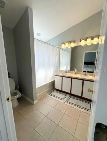 a spacious bathroom with a double vanity sink and mirror