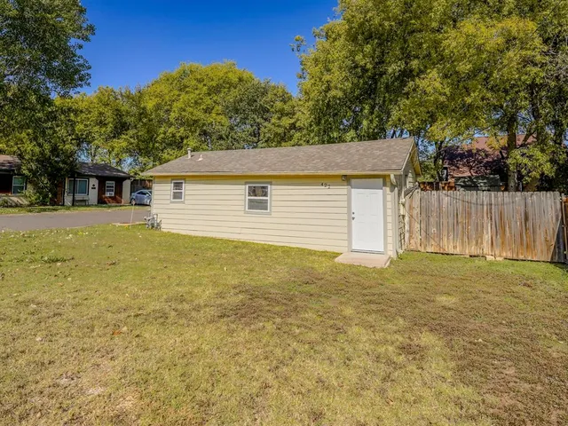 a front view of house with yard and trees in the background