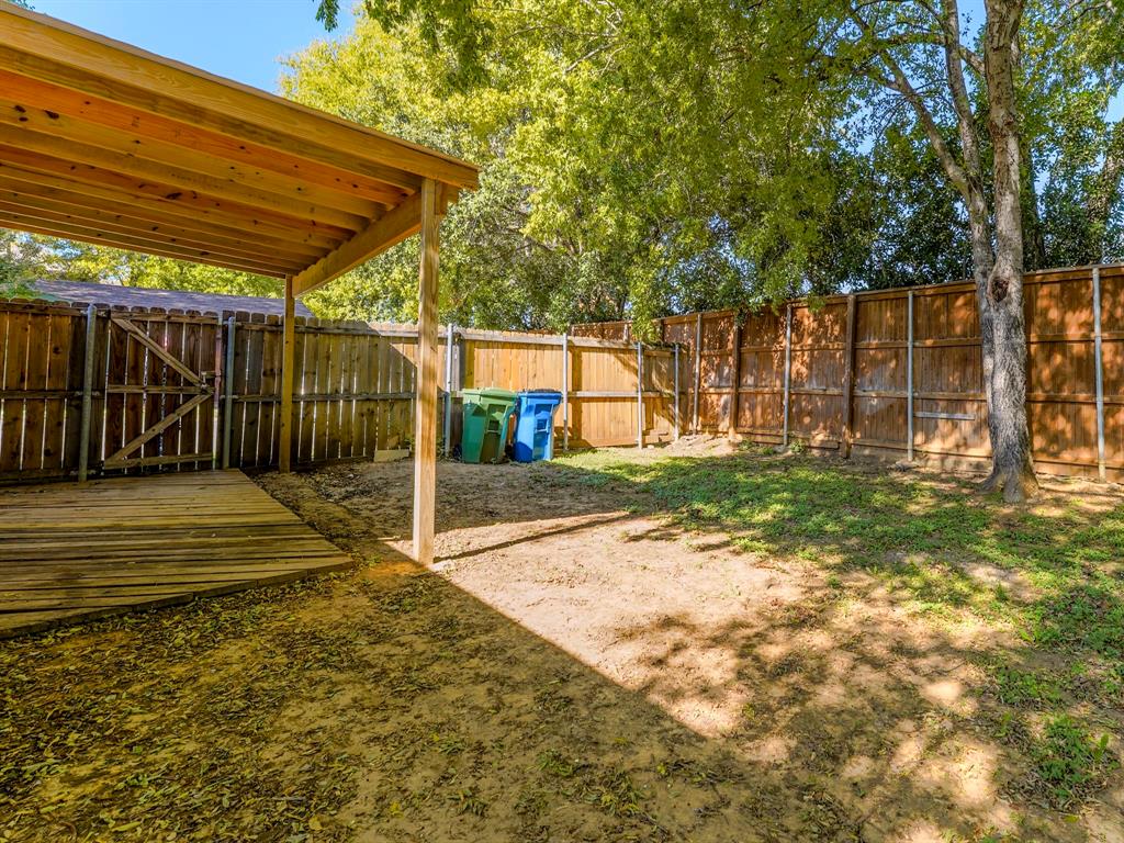 422 Washington Street Grapevine, TX 76051 - Photo 12 of 16 a view of backyard with wooden fence and a large tree