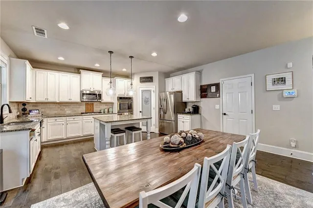 a kitchen with stainless steel appliances granite countertop sink stove a refrigerator and wooden floor